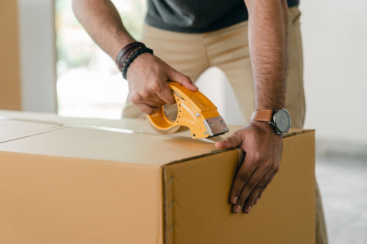 Plain corrugated carton being sealed for dispatch